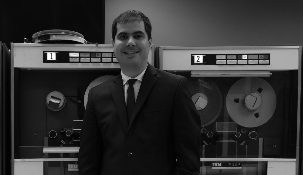 Joël Franusic standing in front of two IBM 729 reel-to-reel tape machines for the IBM 1401