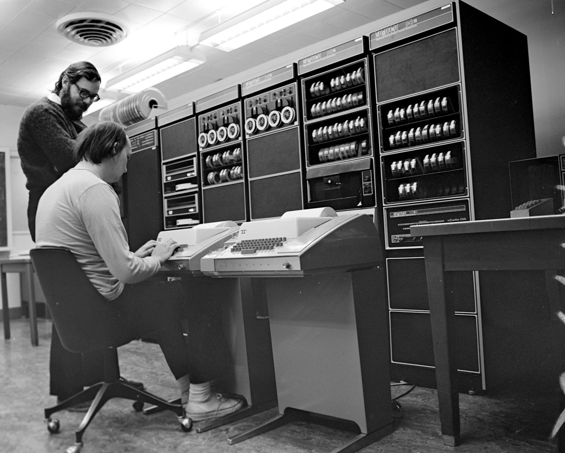 Ken Thompson and Dennis Ritchie sitting at a teletype in front of a PDP-11